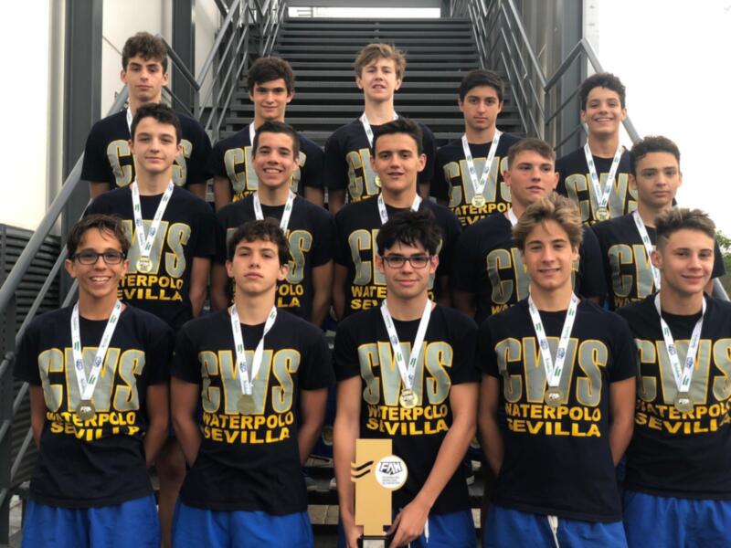 Equipo de waterpolo juvenil con medallas y trofeo, celebrando su victoria.
