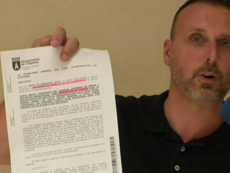 Persona hablando mientras sostiene un documento oficial del Ayuntamiento de Chipiona.