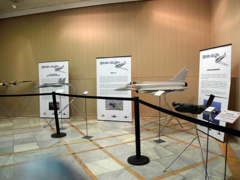 Exposición de modelos de aviones militares en un museo, destacando el Eurofighter y otros aviones históricos.