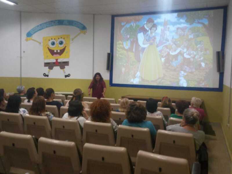 Clase de animación con proyección de dibujos animados en una sala de conferencias.