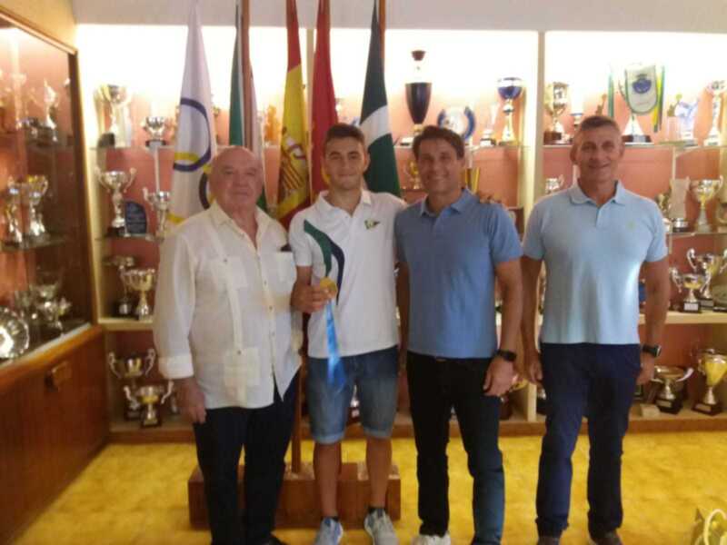 Celebración de logros deportivos en un ambiente con trofeos y banderas.