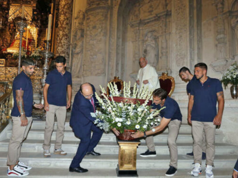 Ofrenda floral en una ceremonia religiosa en un templo con decoración barroca.