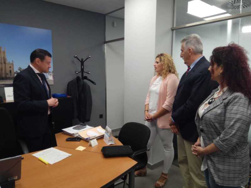 Reunión de trabajo en un entorno profesional. Personas en trajes discutiendo en una oficina.