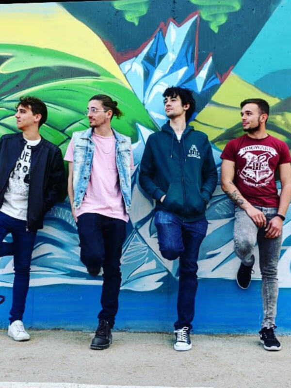 Tres jóvenes posan frente a un mural vibrante, mostrando una combinación casual de ropa con detalles urbanos.