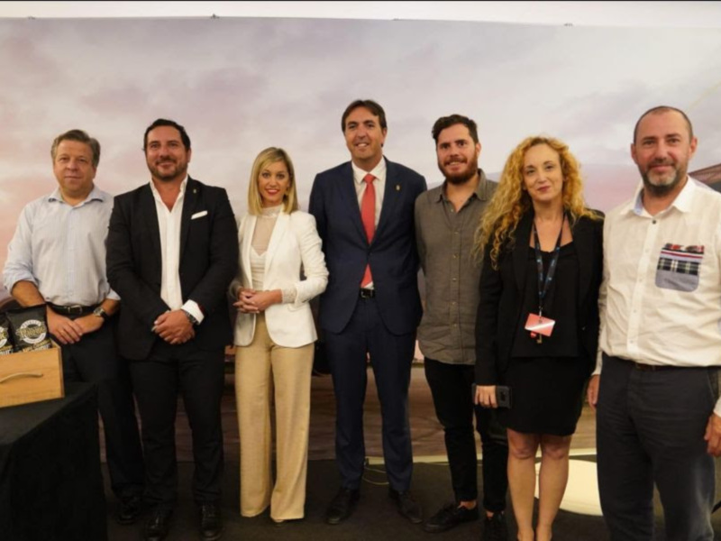 Grupo de personas en una reunión formal, posando juntos en un evento público.