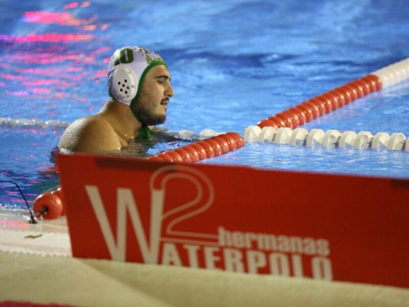 Un nadador en una piscina con un casco de natación y una línea de natación roja en el fondo.