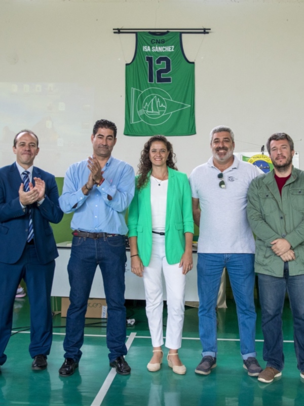 Celebración en un gimnasio con una camiseta de baloncesto colgada en el fondo.