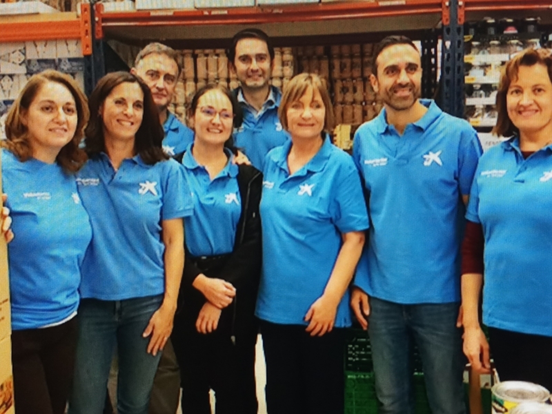 Equipo de trabajo unido en un supermercado, todos con camisetas azules.