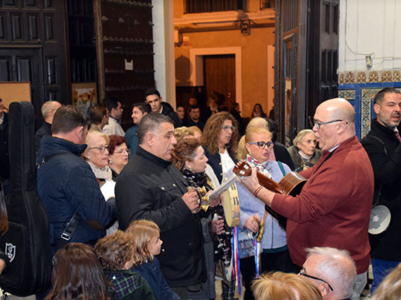 Concierto de música tradicional en un espacio histórico, con músicos tocando instrumentos y un público atento.