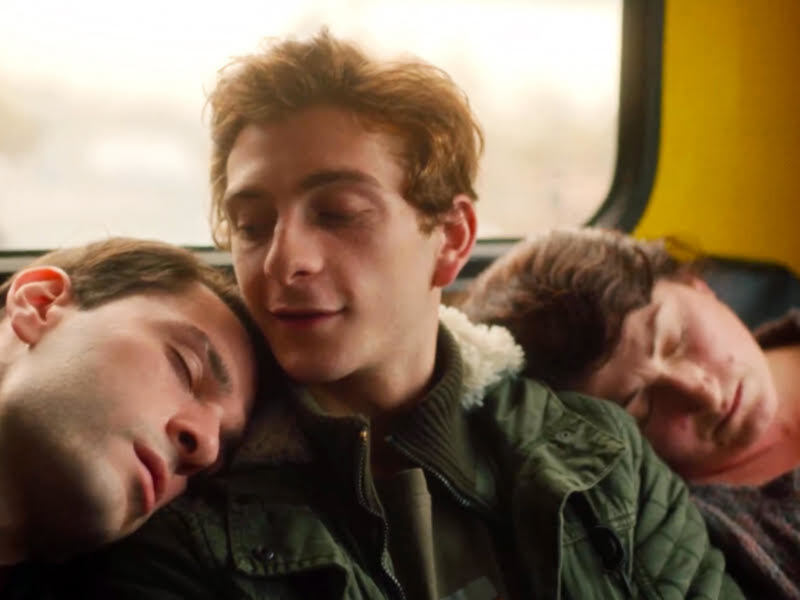 Tres amigos descansando en un autobús, con un ambiente acogedor y relajado.