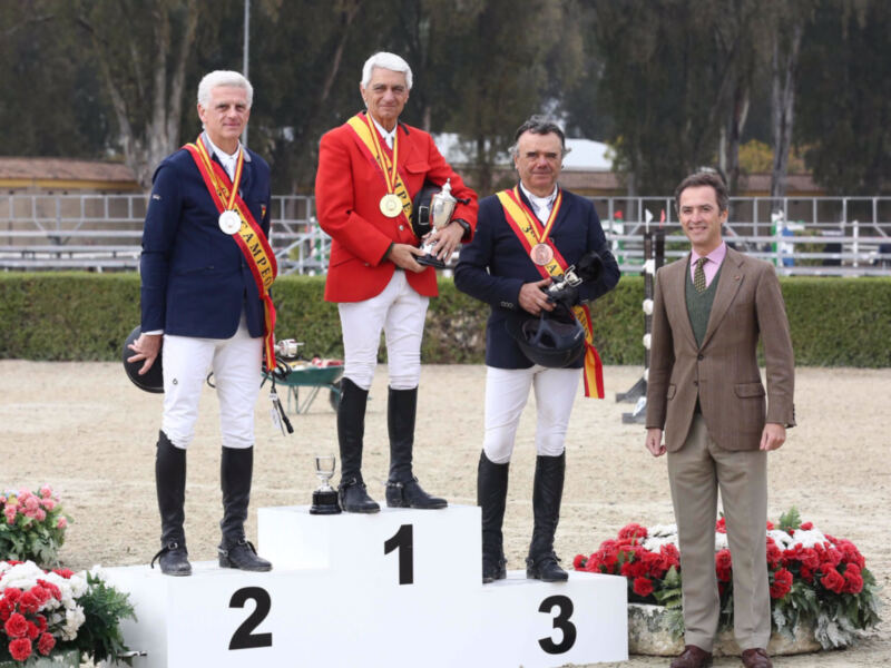 Premio a los ganadores de un concurso ecuestre en un podio con trofeos y medallas.