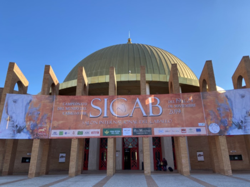 Exterior del Salón Internacional del Caballo (SICAB) en 2019, con su característica cúpula dorada y cartel informativo.