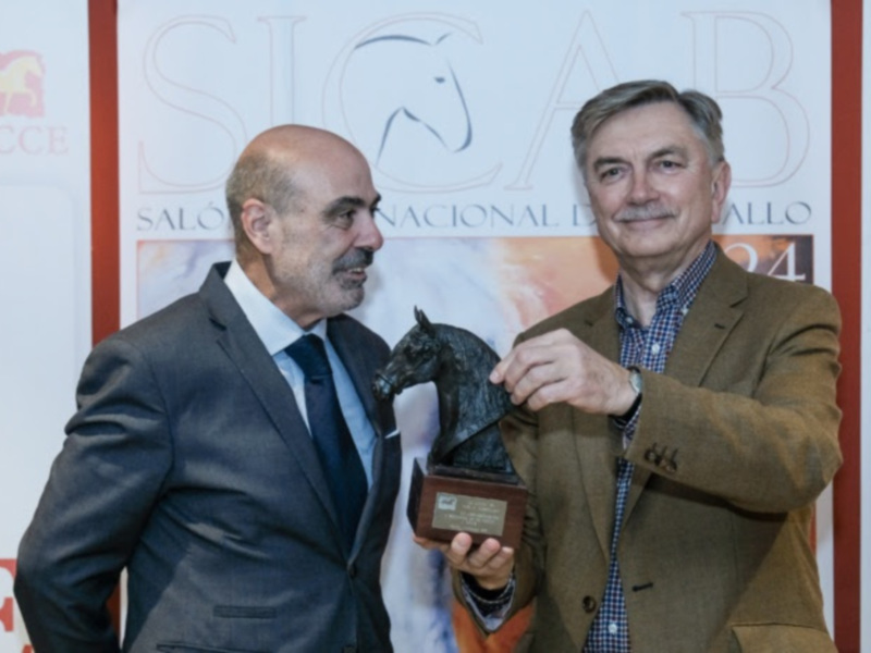 Dos hombres posan con un trofeo de caballo en un evento de la Asociación de Criadores de Caballos de España.