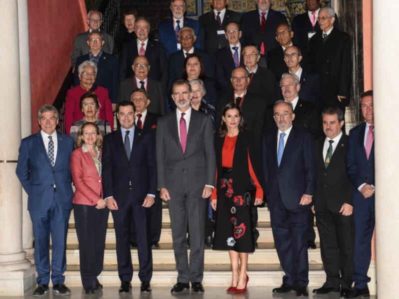 Reunión oficial en un palacio con autoridades y dignatarios en trajes formales.