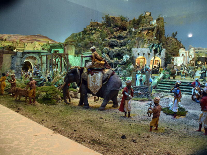 Escena de la Natividad con figuras y un elefante en un belén.