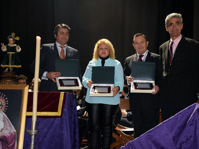 Premiación en evento religioso con representantes sosteniendo placas de reconocimiento.
