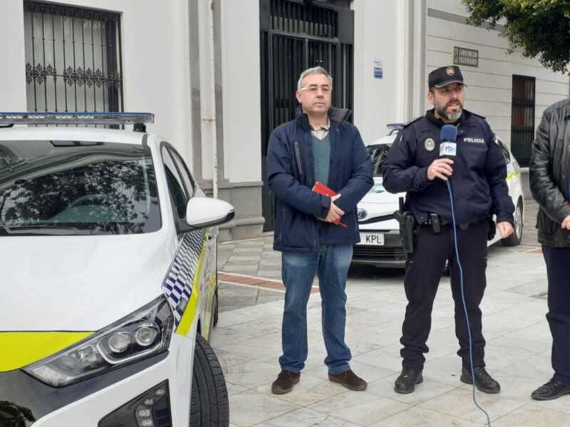 Policía local y autoridades en rueda de prensa frente a un vehículo patrulla.