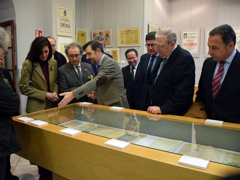Visita de autoridades a una exposición de documentos históricos en un museo.