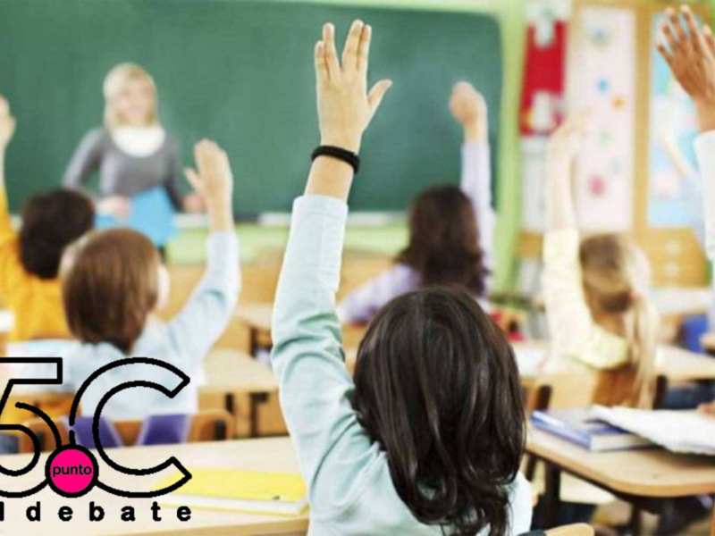 Estudiantes levantando la mano en una sala de clase, participando activamente en una discusión o actividad educativa.
