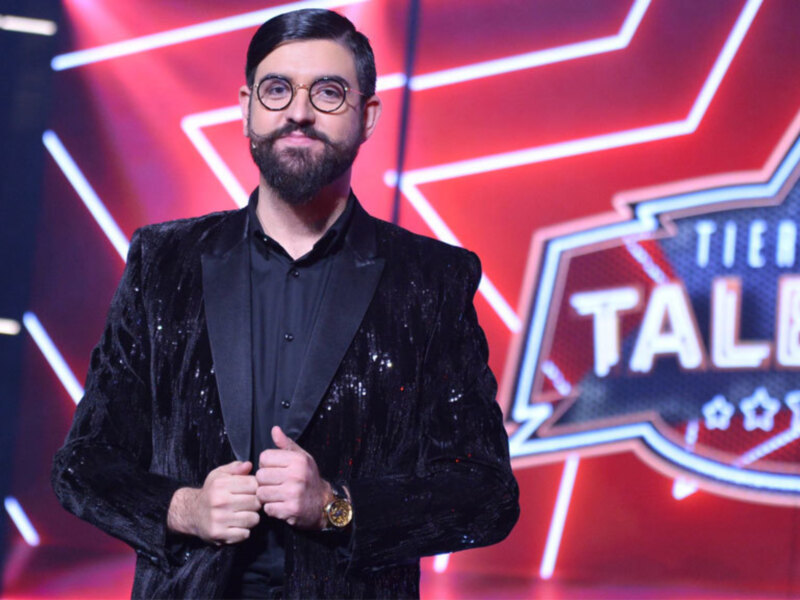 Participante de 'Tierra de Talento' en un escenario con iluminación dramática y fondo estelar.