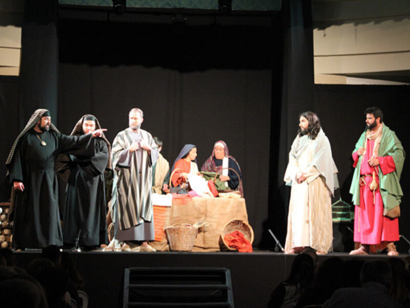 Actores en trajes bíblicos representando una escena histórica en un escenario teatral.