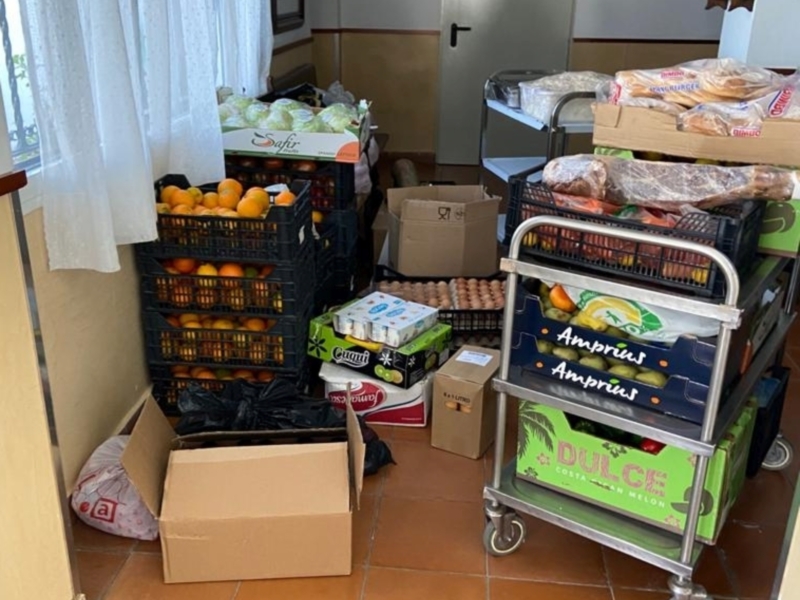 Unidades de almacenamiento de frutas y verduras en una cocina, con cajas de naranjas, huevos y otros productos frescos.