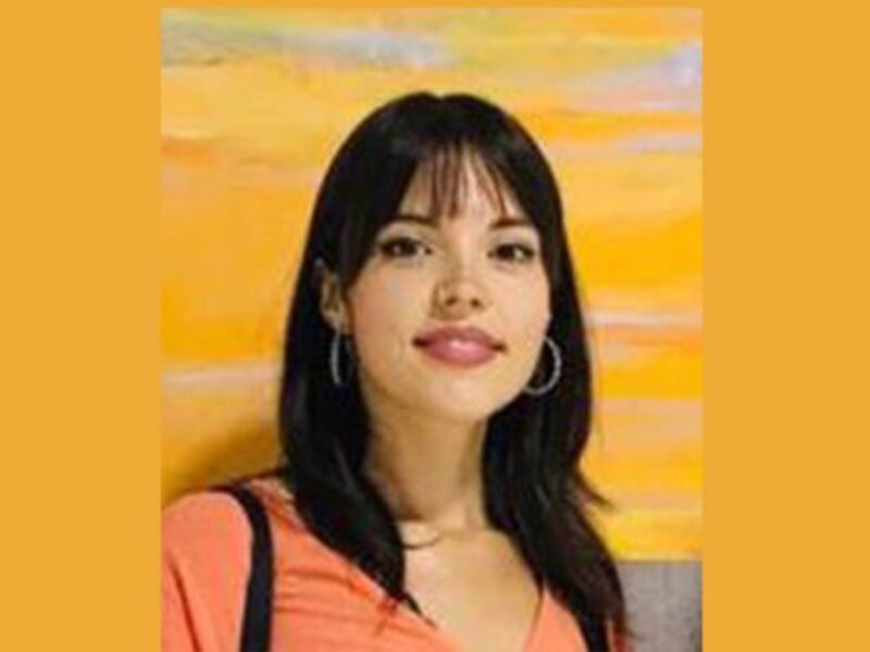 Retrato de mujer joven con cabello largo y liso, sonriendo frente a un fondo abstracto amarillo y beige.