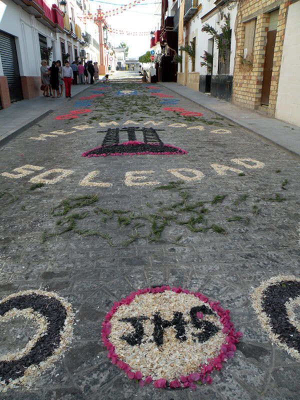 Festividad con alfombras de flores y mensajes en la calle, España