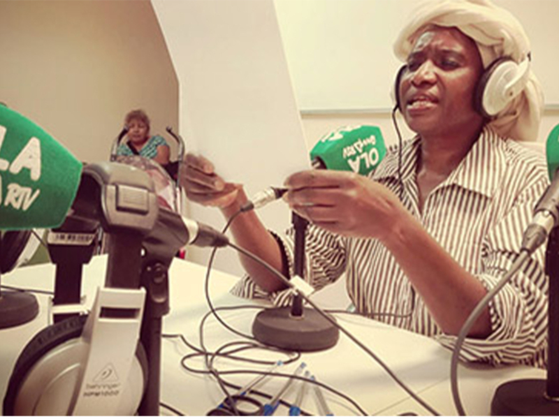 Periodista en acción durante una transmisión radiofónica en un estudio de radio bien equipado.