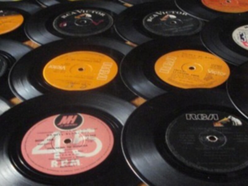 Colección de discos de vinilo antiguos con etiquetas de diferentes marcas y estilos.