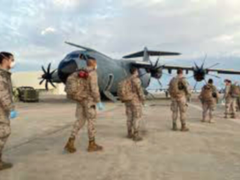 Fotografía de soldados en el aeropuerto, con un avión militar en el fondo.