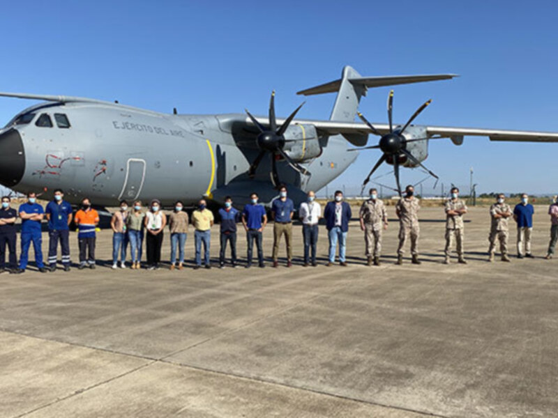 Grupo de personas en uniforme frente a un avión militar en una pista aérea.