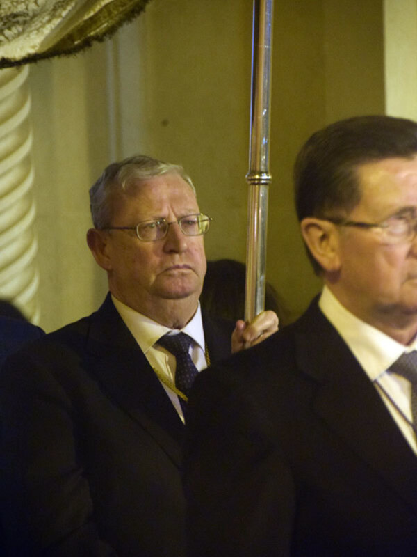 Dos hombres en trajes de negocios en una ceremonia formal.