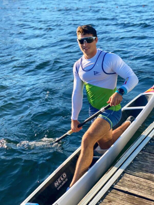 Atleta en canoa, listo para competir en un día soleado.