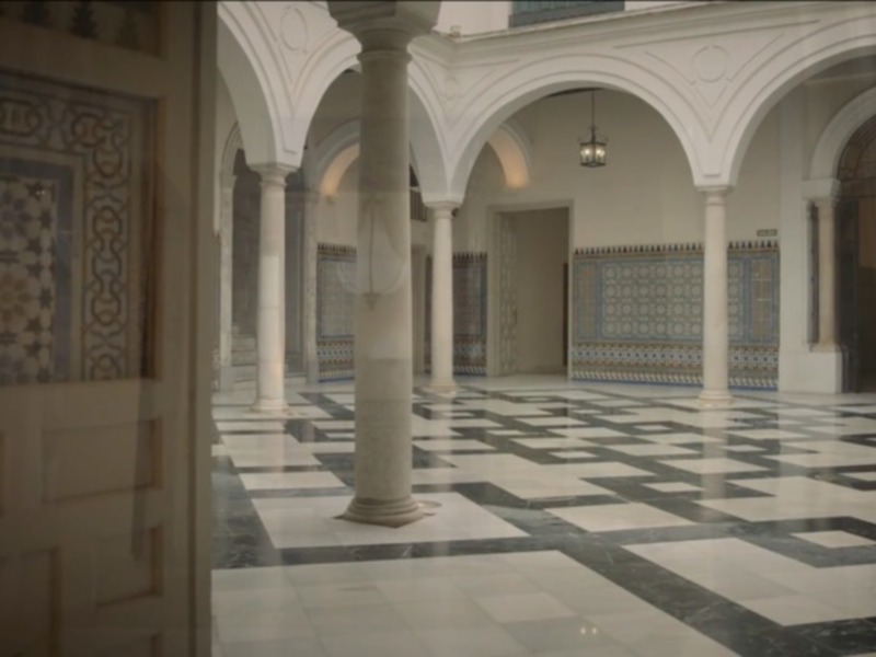 Interior of a traditional Moroccan building with ornate tilework and marble flooring.