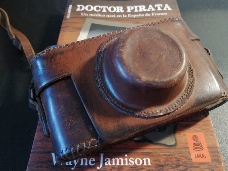 Carcasa de cámara de cuero vintage sobre el libro 'Doctor Pirata'.