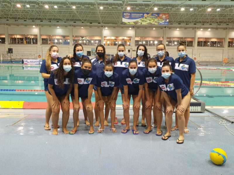 Equipo de natación sincronizada posando en la piscina, con uniformes y mascarillas.