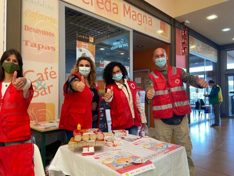 Voluntarios de Cruz Roja en un evento de donación de alimentos en un centro comercial.