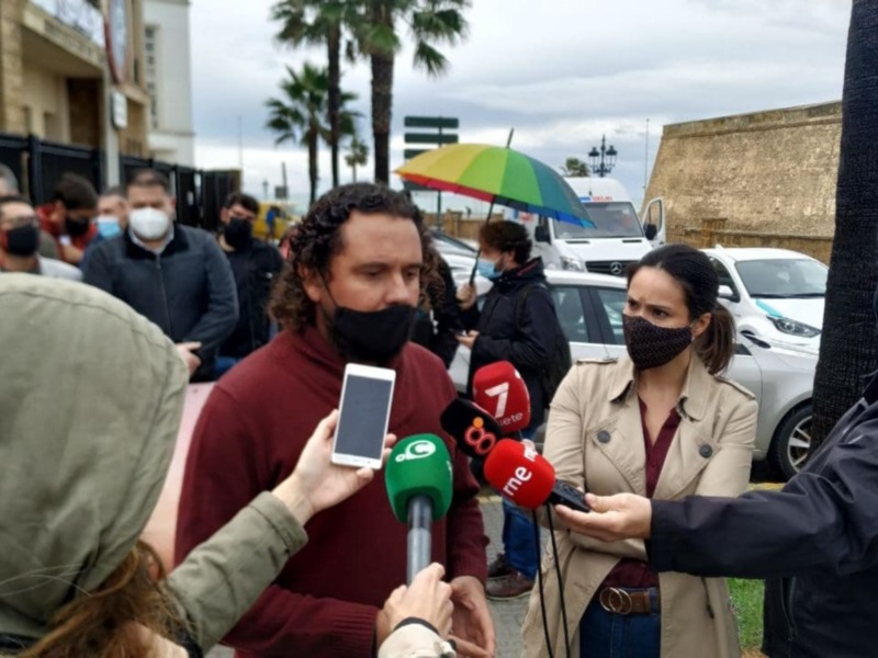 Person being interviewed by reporters in a public setting.