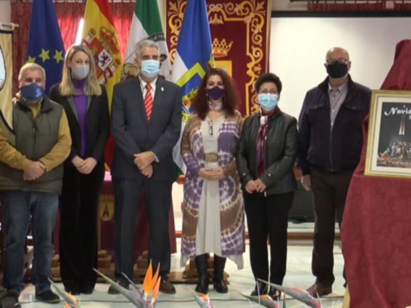 Presentación oficial en un evento con banderas y decoración navideña.
