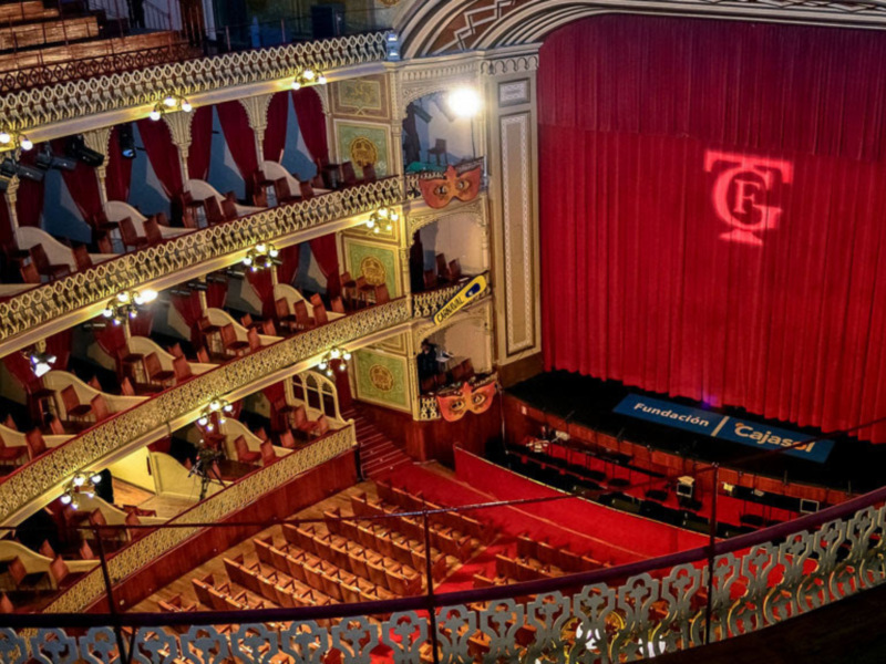 Interior del Teatro Colón, con su elegante decoración y escenario vacío, listo para una presentación.