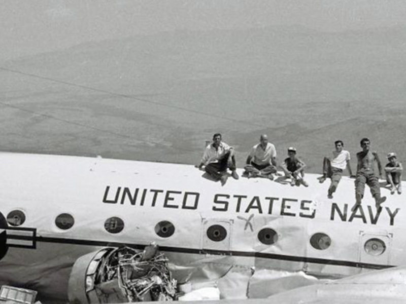 Un avión de la Armada de los Estados Unidos con personal militar en la parte superior durante una operación militar en el desierto.