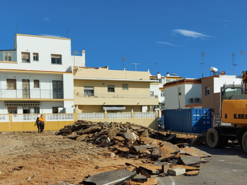 Trabajos de demolición y excavación en un entorno urbano bajo un cielo azul claro.