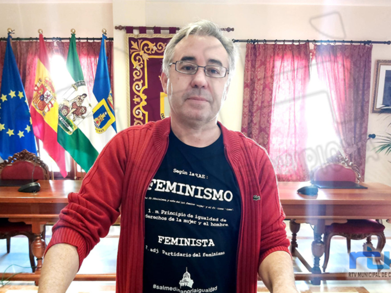 Persona en oficina con banderas y textos sobre feminismo y la igualdad de género.