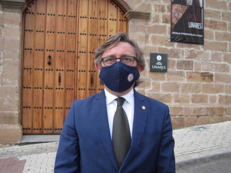 Persona con traje y máscara frente a la entrada del Centro de Interpretación de Linares.