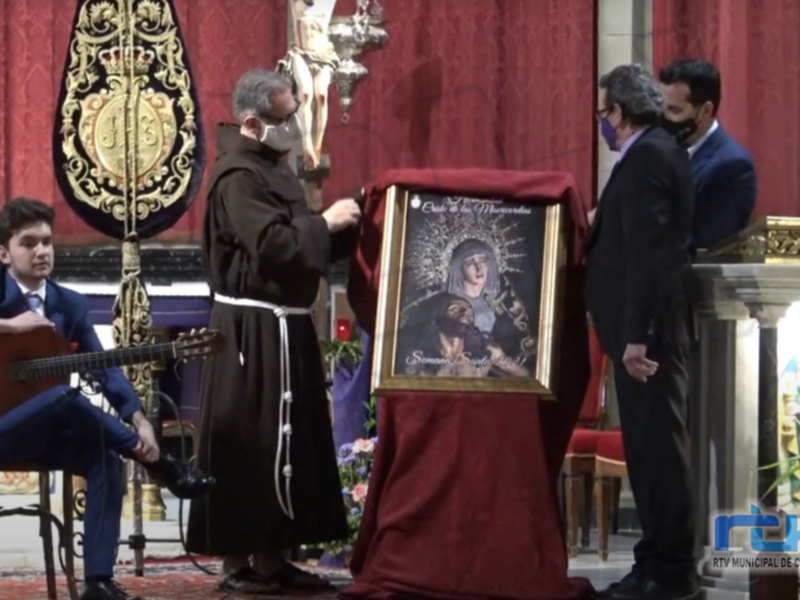 Ofrenda de imagen religiosa durante la Semana Santa en Chipiona, con músico y sacerdote en el altar.