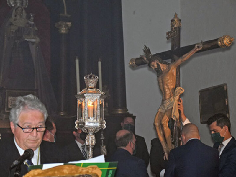 Celebración religiosa con un Cristo en la cruz y una procesión en un interior de iglesia.