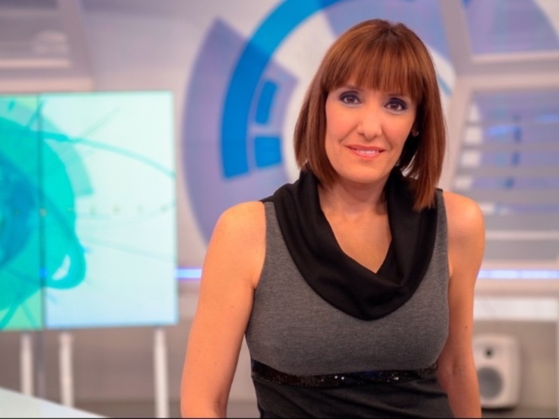 Presentadora en estudio de televisión con fondo abstracto y tecnología.