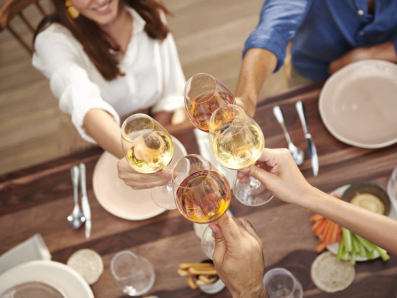 Celebración con copas de vino en una mesa de comedor.