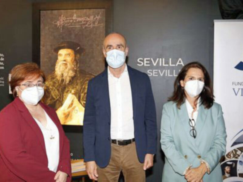 Presentación en Sevilla de la Fundación Nao Victoria con retrato de Cristóbal Colón y personas con mascarillas.